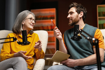 Two podcasters recording a new episode in a studio