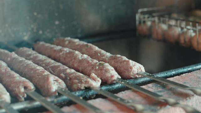 Sizzling lula kebabs grilling on metal skewers, rotating for uniform browning over high heat, releasing savory aromas