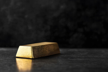 Single Gold Bar on Sleek Black Table Under Dramatic Lighting black background