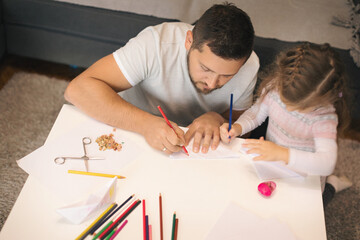 Father and his cute little girl crafting airplane from papper
