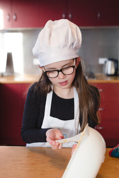 Girl scraping bowl cooking cake