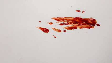 Blood splatters and smears on a white surface, close-up shot