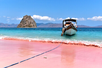 Pink beach with clear turquoise water and boat on Padar island near Komodo island © Klara Bakalarova