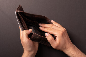 Close-up of an empty brown leather wallet.  Illustrates financial hardship, poverty, or bankruptcy.