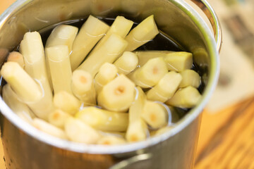 Close-up of blanched asparagus spears in a metal bowl, ready for cooking.