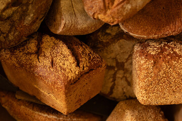 Close-up of various artisan sourdough bread loaves, showcasing textures and colors.