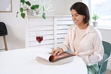 Pretty young woman reading menu in cafe