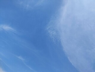 Fototapeta premium Bright blue sky with scattered thin clouds, natural background