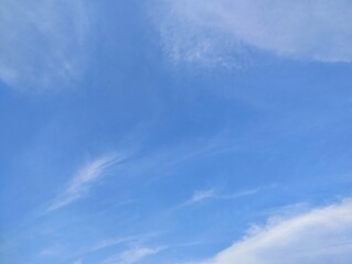 Bright blue sky with scattered thin clouds, natural background