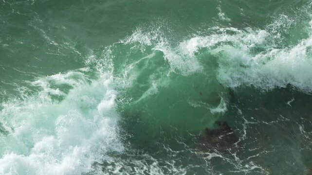 Ocean waves turquoise water crashing near rocks during daytime splashing