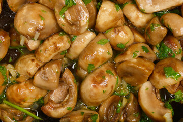 A close-up shot shows sauteed mushrooms glistening with sauce and sprinkled with fresh herb