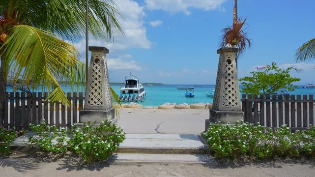 Landscape view with coconut trees and turquoise water on Nusa Parida Island, Indonesia.