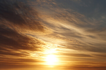 Fototapeta premium Golden sunrise sky with warm sunlight and dramatic clouds, creating peaceful and inspiring morning atmosphere, perfect for nature and landscape backgrounds