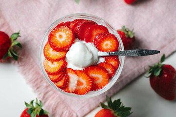 Minimalist food composition with a focus on healthy eating — Greek yogurt and strawberries captured in natural light.