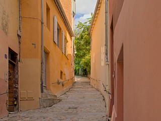 Cobblestone alley with traditional houses in pastel colours in the city of Lyon, France 