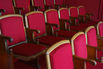 Empty rows of retro, old red theater or cinema seats. Old style, vintage chairs with red upholstery...