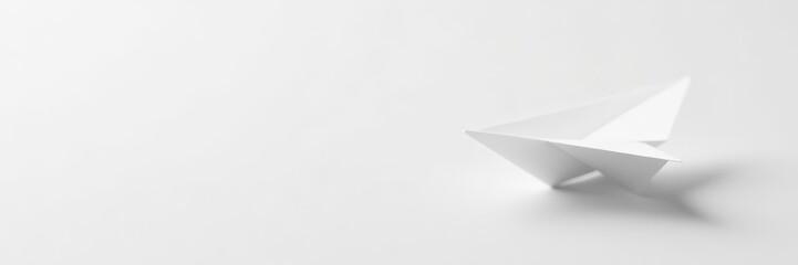 Fototapeta premium Minimalistic white paper airplane on white background with soft shadows, symbolic, travel
