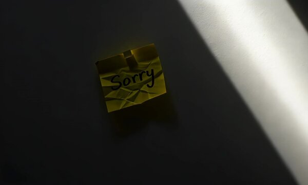 Crumpled sticky note with "Sorry" message in dramatic light - Powered by Adobe