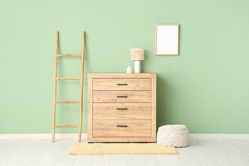 Interior of room with wooden commode, ladder and blank frame