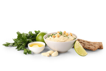 Bowl of tasty hummus with ingredients and crackers on white background
