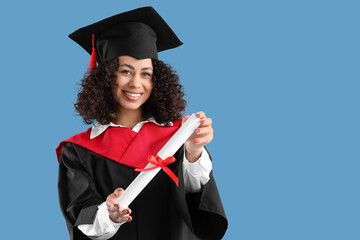Happy African-American female graduate with diploma on blue background