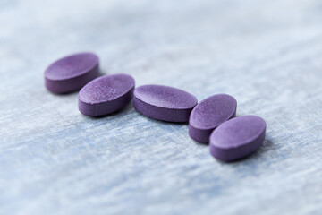 Lutein tablets. Dietary supplement on wooden background. Soft focus. Close up. Copy space	