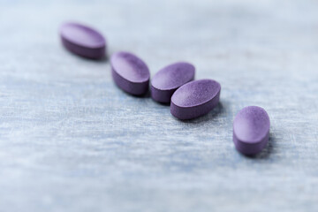 Lutein tablets. Dietary supplement on wooden background. Soft focus. Close up. Copy space	