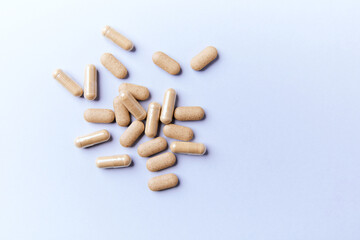 Ashwagandha (Withania somnifera) tablets and capsules on paper background. Soft focus.. Close up. Copy space.	