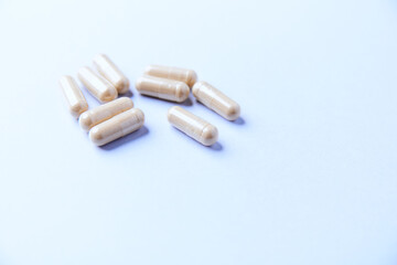 Ashwagandha (Withania somnifera) capsules. Concept for a healthy dietary supplementation. Bright paper background. Close up. Copy space.	