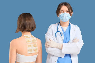 Female doctor and patient with mustard plasters on blue background