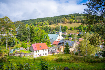 Overlooking Jachymov, the Church of St. Joachim stands proudly among lush greenery and serene...