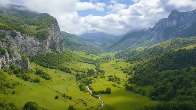 Lush Green Valley with Jagged Rocky Cliffs Under Cloudy Sky in Daytime
