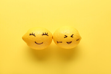 Fototapeta premium Funny lemons with drawn faces on yellow background. Friendship Day celebration