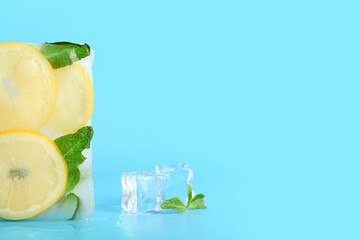 Lemon slices and mint in ice on color background