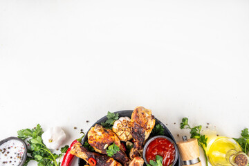Grill and barbeque season recipes. Grilled chicken legs with garlic, spices, parsley, bbq sauce and olive oil. Tasty broiler drumstick ready for dinner on lunch. Chicken meat, barbecue menu background