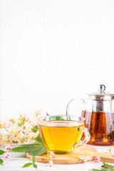Organic natural chestnut leaves and flower tea. Hot alternative non-caffeine herbal drink, tasty healthy beverage, on white wooden background copy space