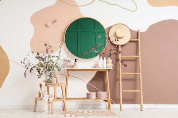 Interior of bathroom with blossoming branches, mirror and ladder
