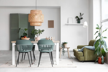 Interior of light dining room with table and green sofa