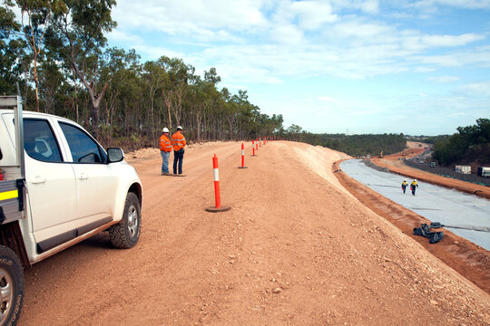 View of workers and heavy machinery on a road construction worksite