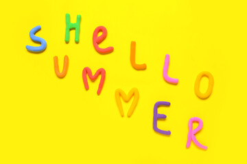 Text HELLO SUMMER made of play dough on yellow background