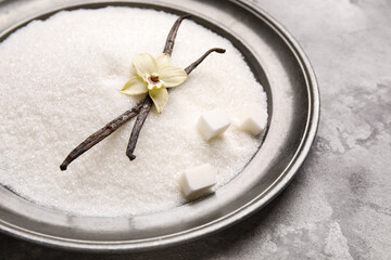 Plate of sweet vanilla sugar on grunge background, closeup