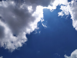 Bright blue sky with fluffy white clouds on a sunny day. Beautiful blue sky and clouds with...