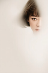 minimalistic portrait emphasizing eyes featuring light background and soft lighting