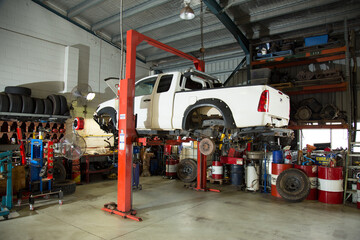 Ute lifted in hoist for repairs in a mechanic workshop