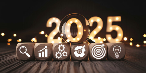 Wooden cubes with business icons, magnifying glass over illuminated 2025, symbolize planning, strategy, and goals for the new year