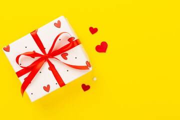 Festive gift boxes with red hearts on color background, top view