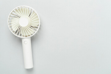 Mini electric fan on color background, top view