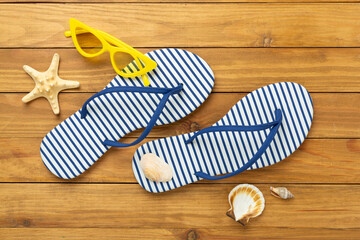 Striped blue flip flops on wooden background, top view