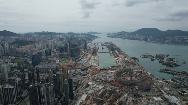 Kai Tak in its development process, surrounded by water and city under cloudy sky in Hong Kong