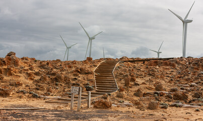 Arid landscape and remnants of Petrified Forest. Steps over rocky hillside at base of Cape Bridgewater Wind Farm in southwestern Victoria, Australia.